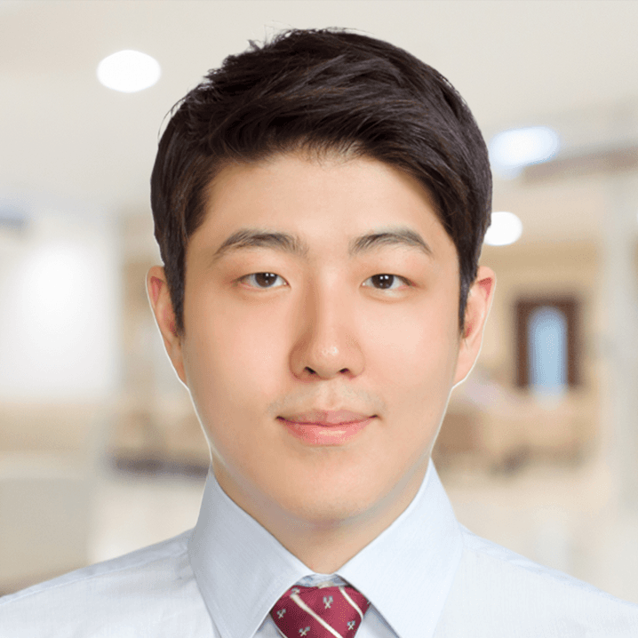 Dr. Cho wearing a white shirt and red tie is smiling for the camera.