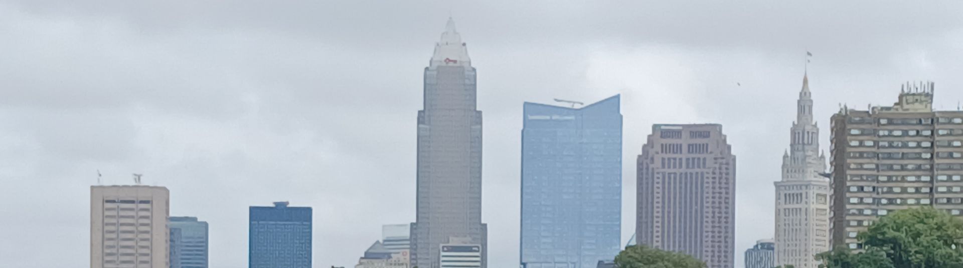 Skyline of Cleveland, Ohio, with skyscrapers under a cloudy sky.