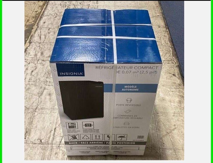 Box of a compact air purifier, blue top, bound with white straps, on a tiled floor.