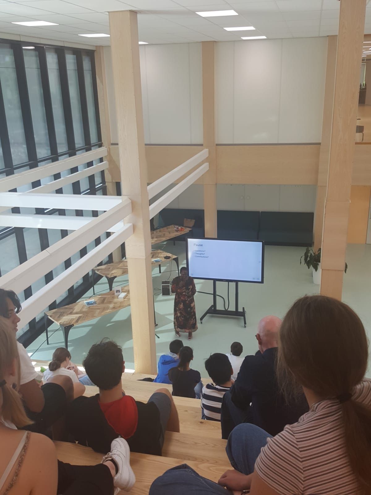 Person giving a presentation to a seated audience in a multi-level atrium.  Discovering Africa in the classroom