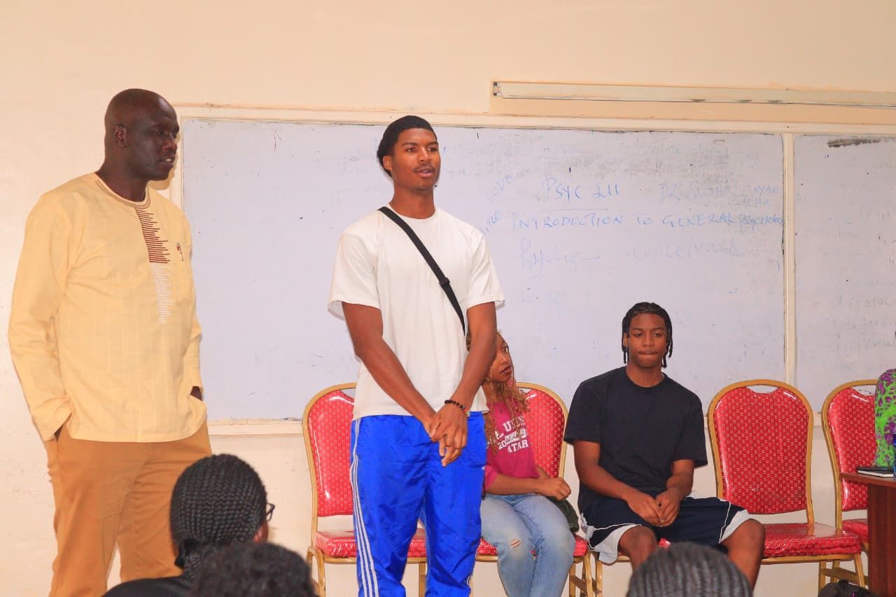 South African craft display: jewelry, flags, and carvings on a table in front of a brick wall.  Discovering Africa in the classroom