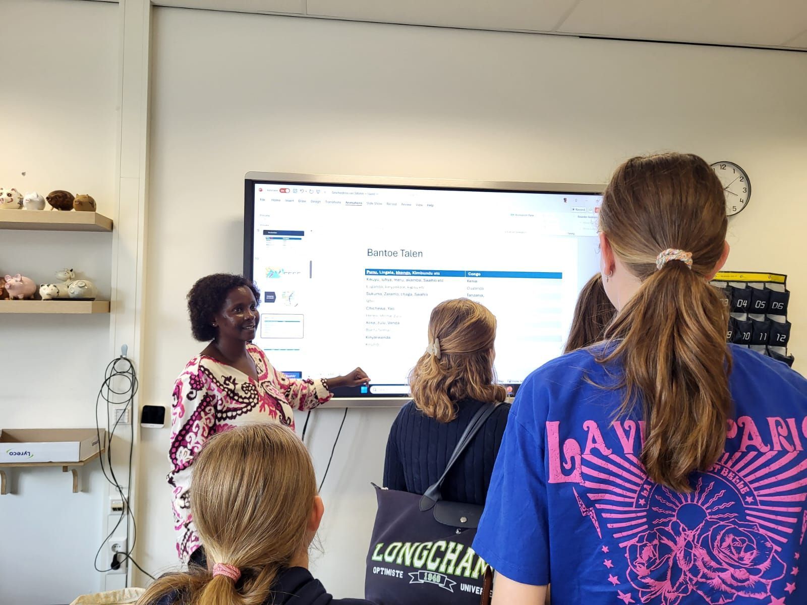 The teacher points at the screen, where the students in the classroom are. Swahili in classroom, Netherlands