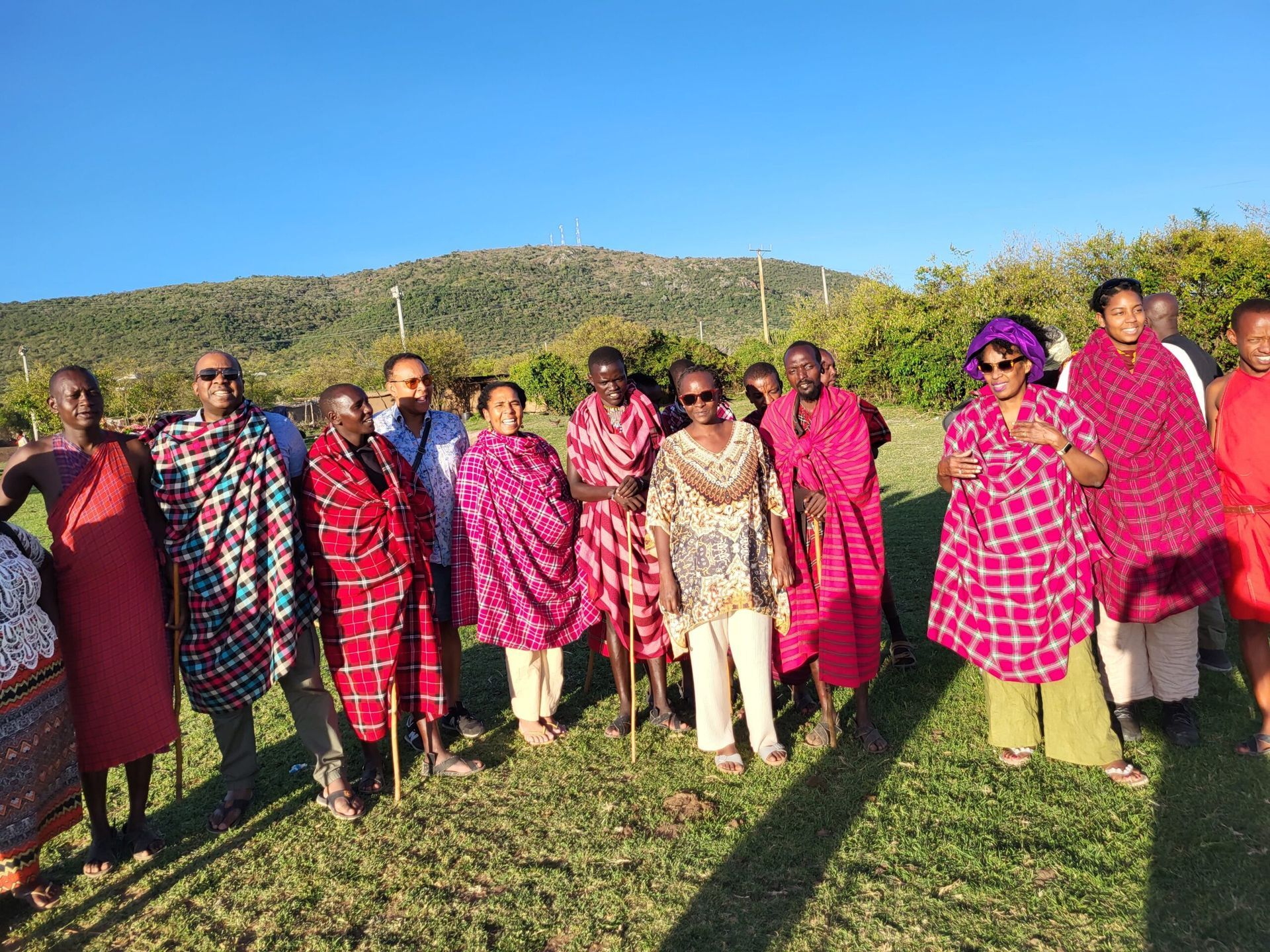 Group of Maasai in traditional dress, posing outdoors on a sunny day. Educultural Travel
