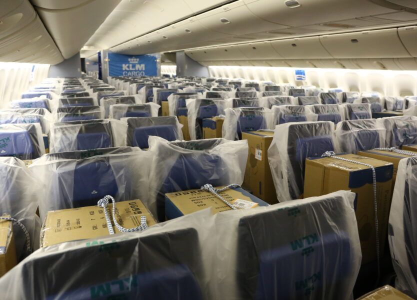 de binnenkant van een klm-vliegtuig met dozen op de stoelen