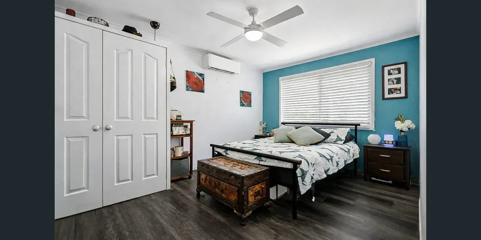 Bedroom With White Walls, Blue Accent Wall, and Wood-look Flooring — Diamond Real Estate QLD in North Lakes, QLD