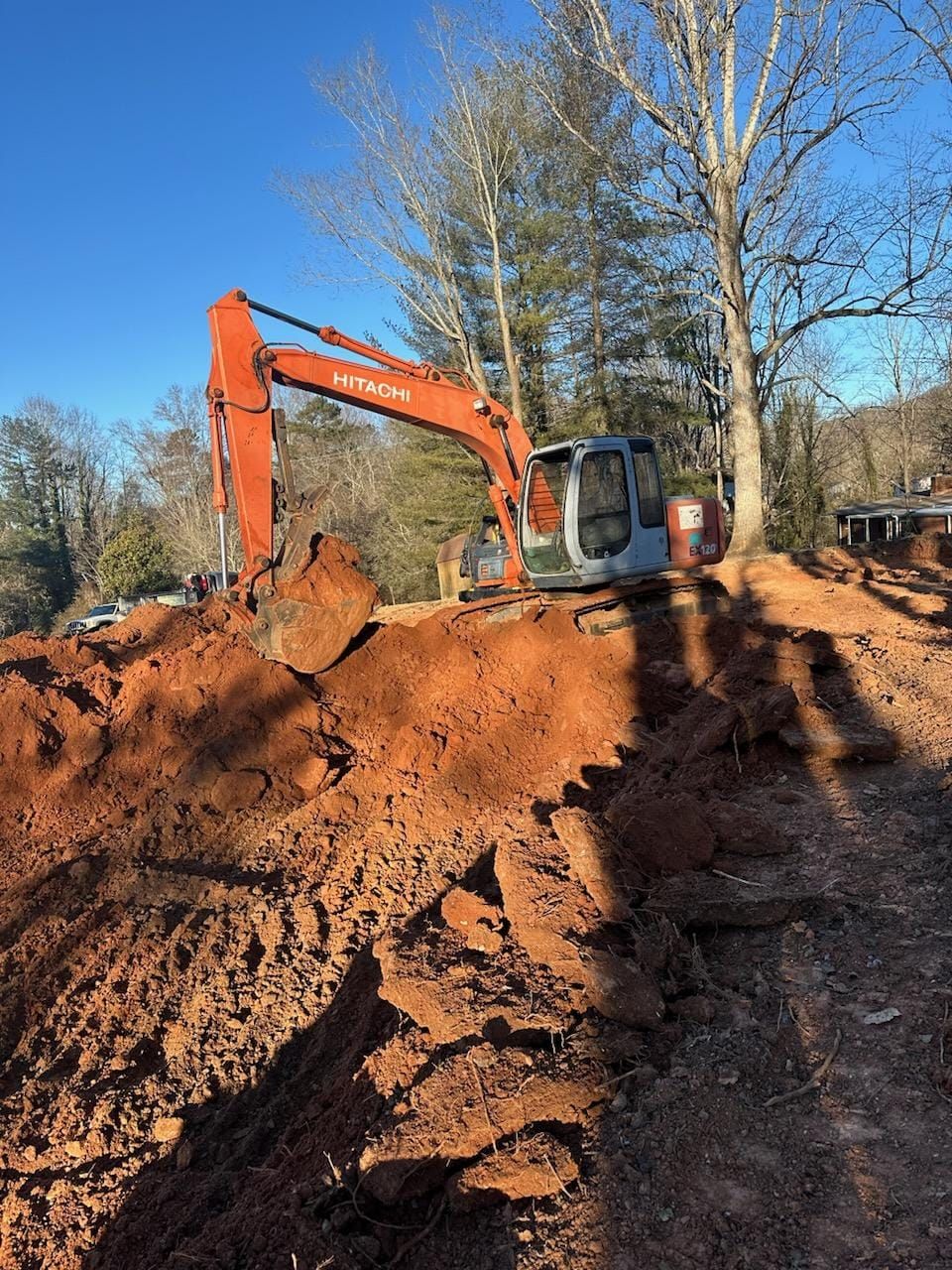 A large excavator is digging a hole in the dirt - Alexander, NC - Land Solutions, LLC