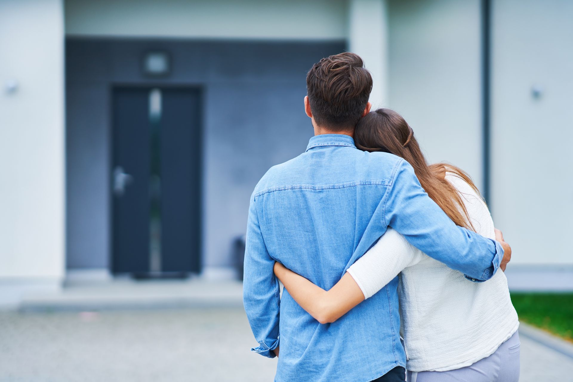 couple hugging each other outside of home