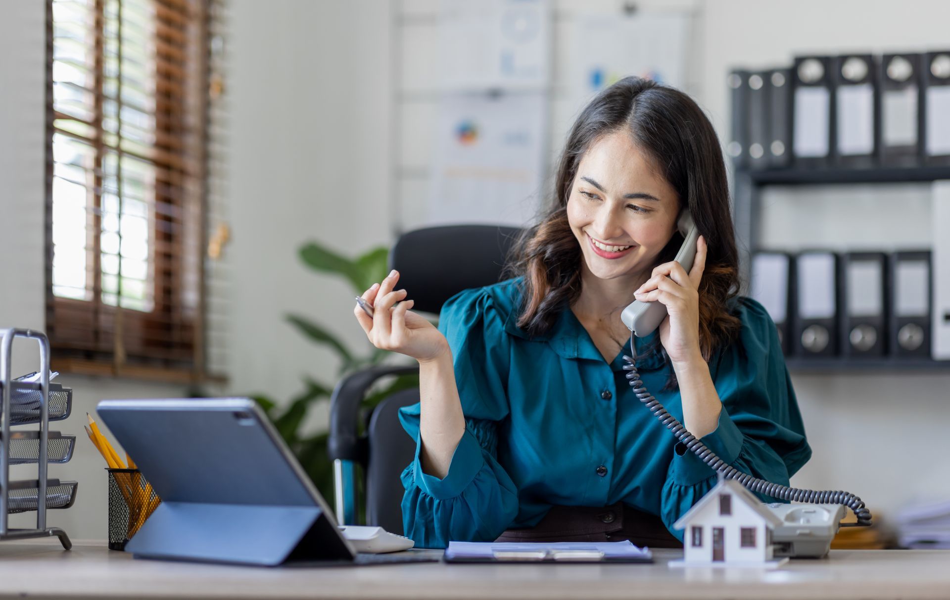 happy woman smiling on phone at desk