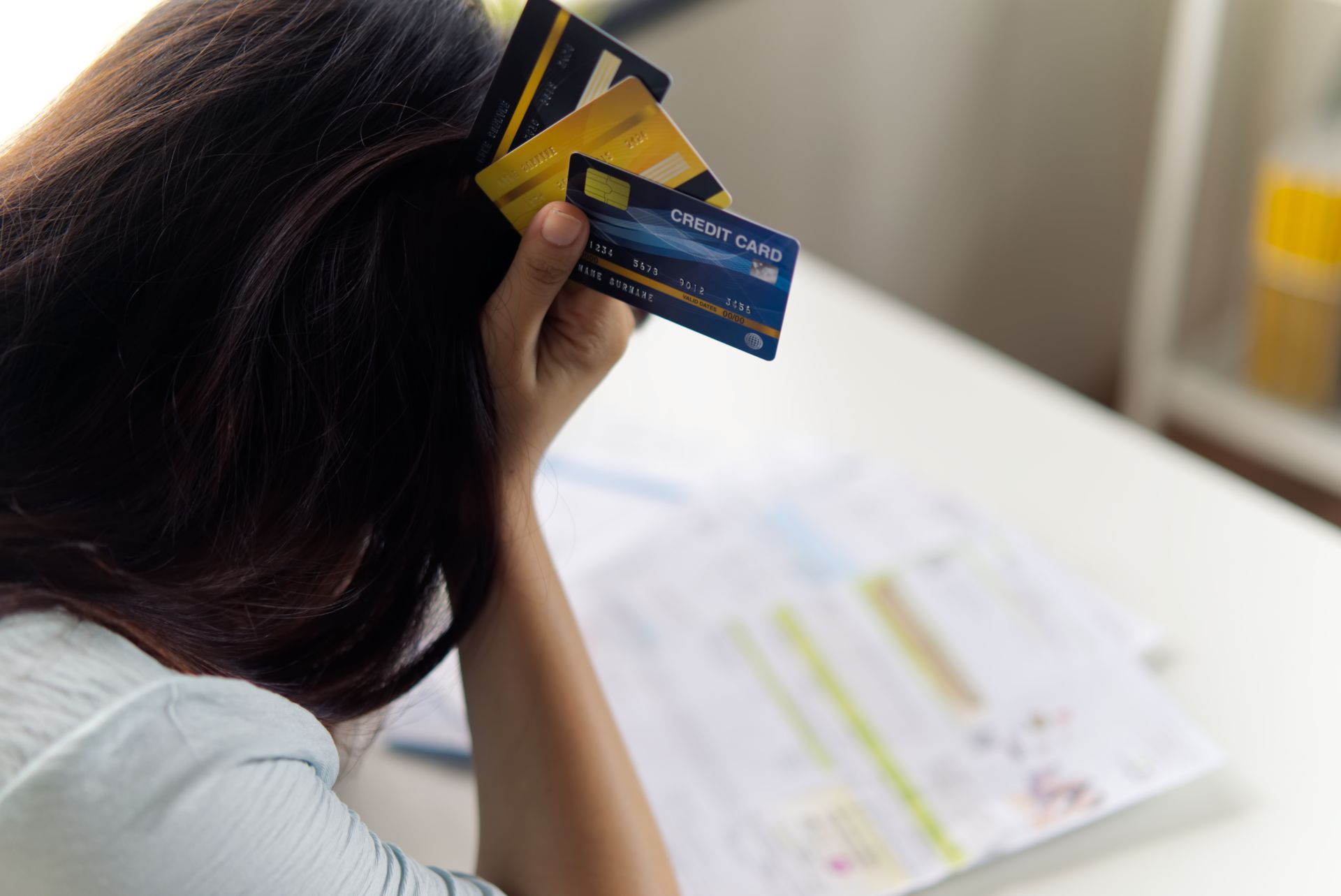 back of woman's head holding credit cards