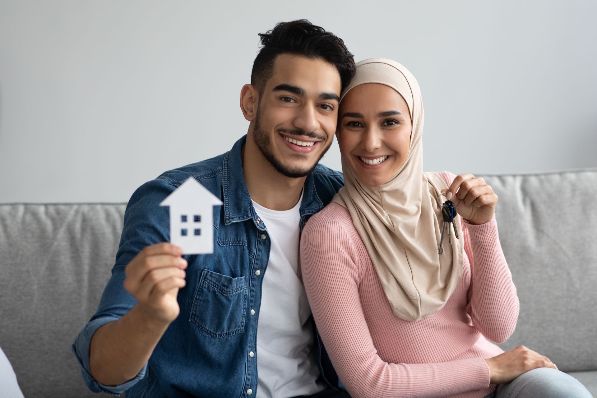 young smiling muslim couple holding their new house keys