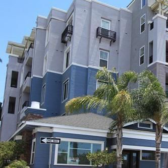 A large apartment building with a palm tree in front of it.