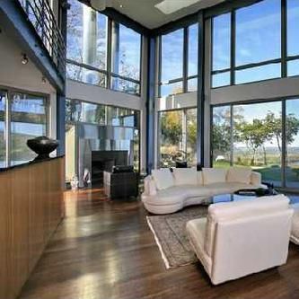 A living room with a couch , chairs , and lots of windows.