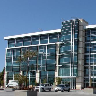 A large building with a lot of windows and cars parked in front of it