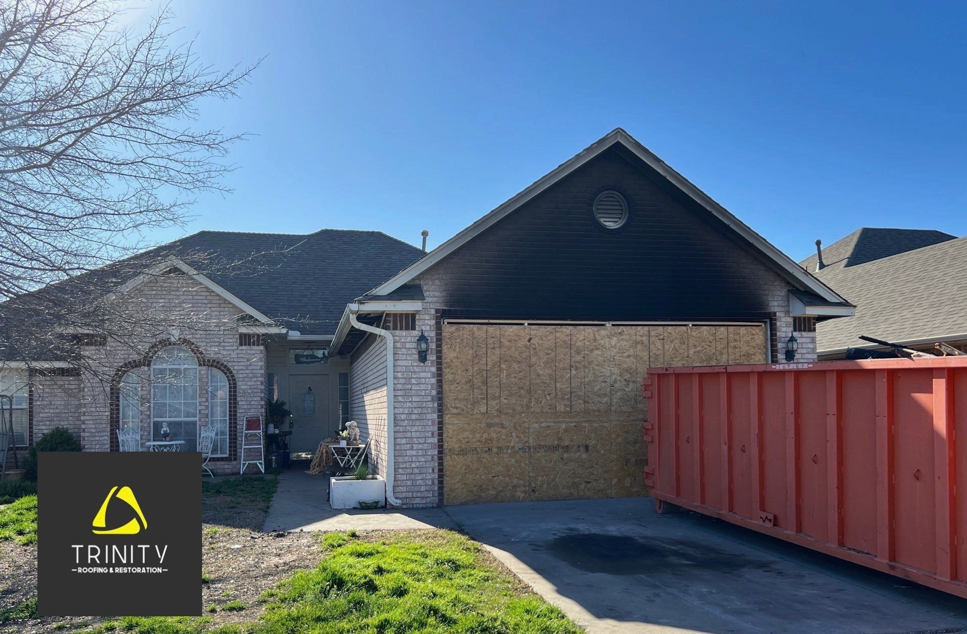 A house with a red dumpster in front of it.