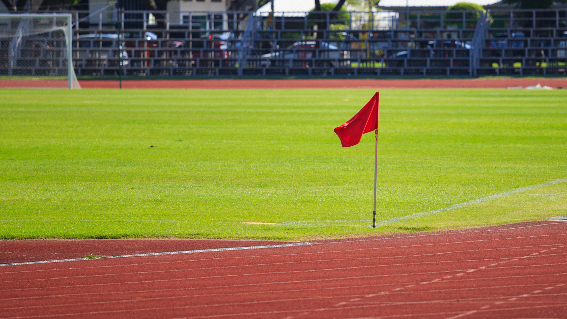 Group of people sitting around a fire at night, some with hands on their faces. Man takes selfie in front.