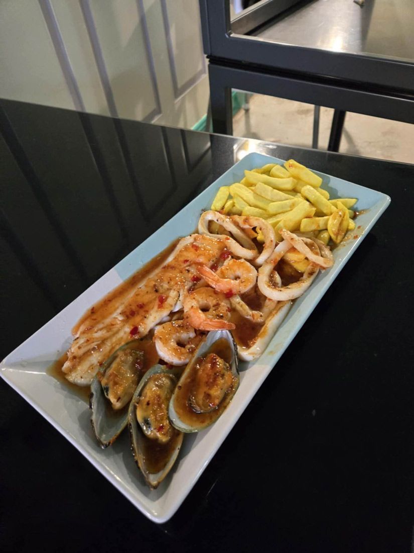 A plate of seafood and french fries on a table — Deep Sea Delights in Taree, NSW