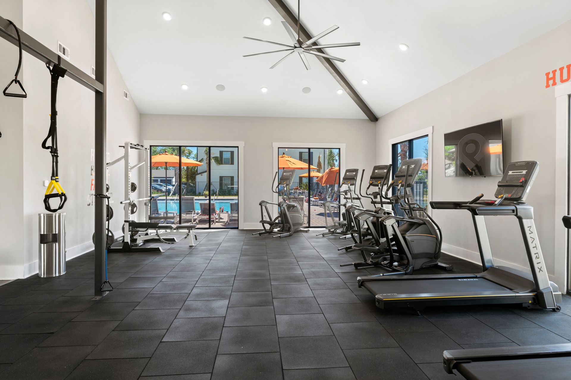 Apartment gym with treadmills, exercise bikes, and a ceiling fan.