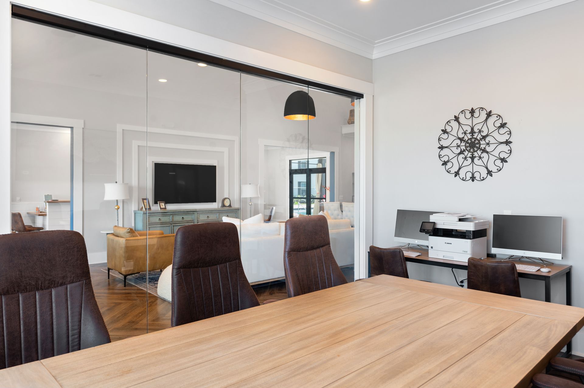 Apartment community conference room with a wooden table and chairs and a clock on the wall.