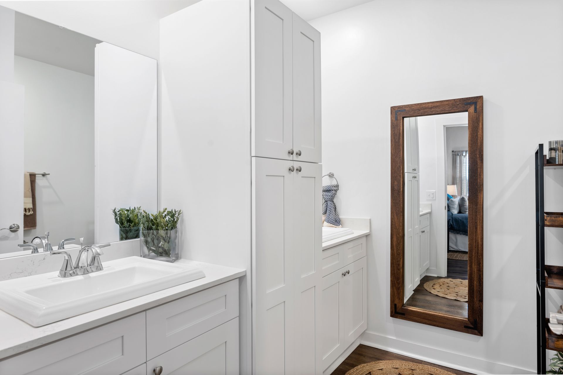 Apartment bathroom with a sink, mirror, and cabinets.
