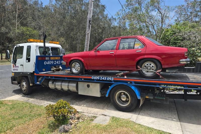 Red Car Loaded on a Tow Truck, Parked on a Residential Street — A Towing Service In Coolongolook, NSW