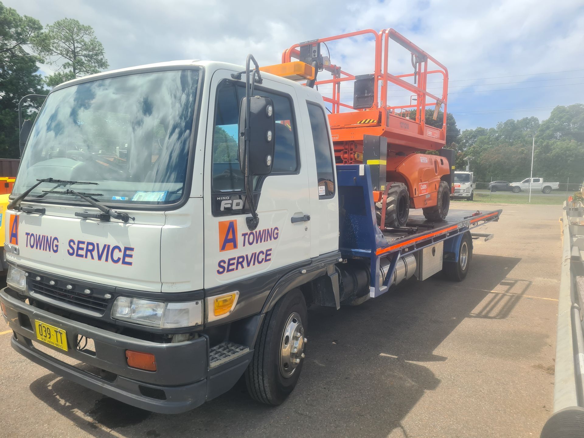 White Tow Truck With an Orange Lift on Its Flatbed — A Towing Service In Coolongolook, NSW