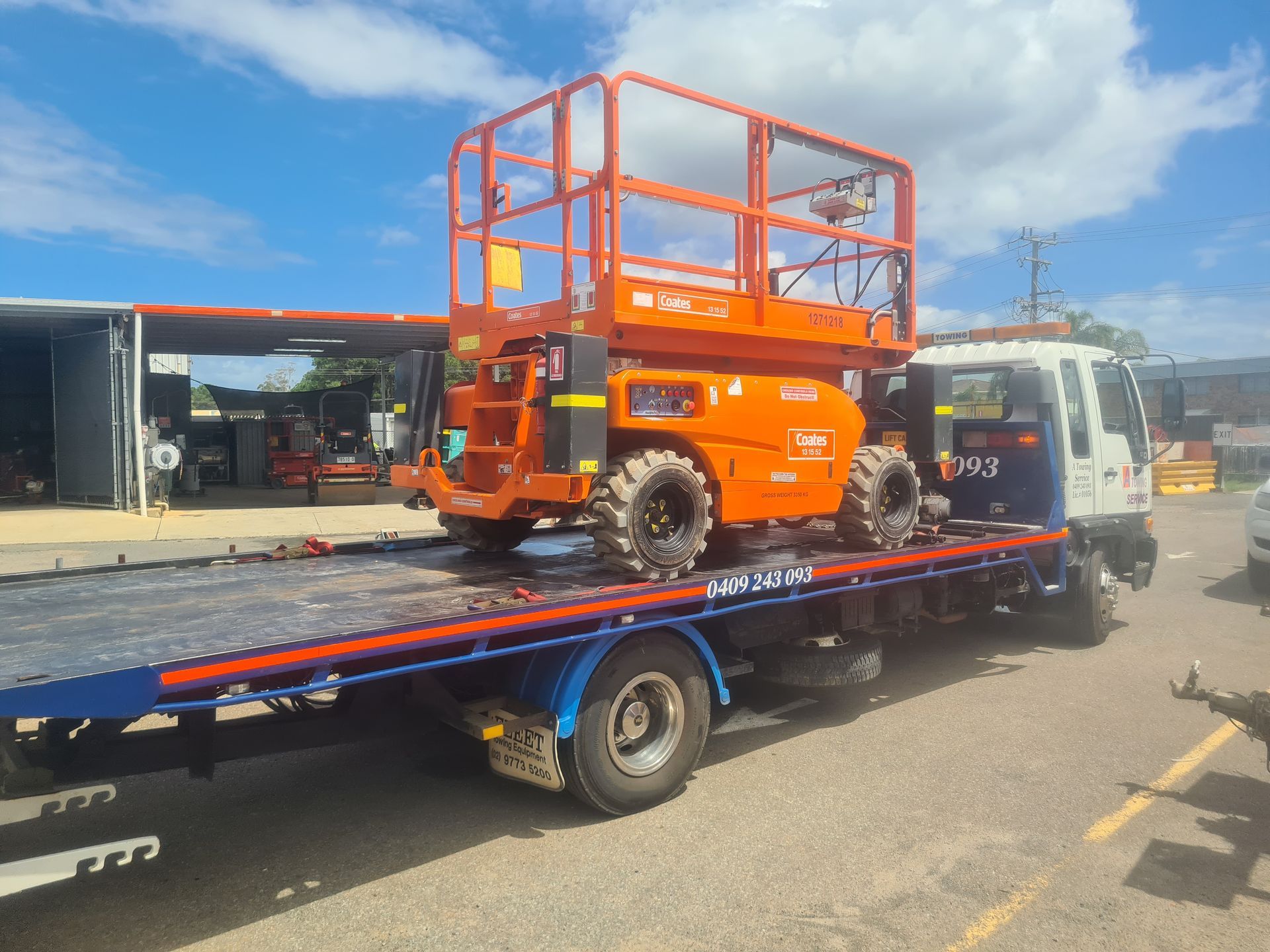Orange Aerial Lift on a Blue Flatbed Truck. Sunny Outdoor Setting — A Towing Service In Pacific Palms, NSW