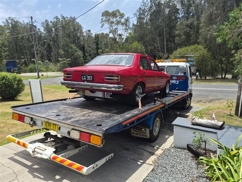 Red Classic Car Loaded on a Tow Truck, Parked on a Residential Street — A Towing Service In Coomba Park, NSW