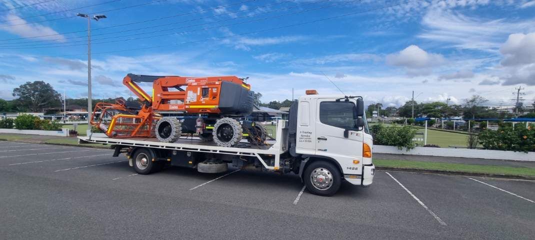 A tow truck is carrying a crane on the back of it. — A Towing Service In Taree, NSW
