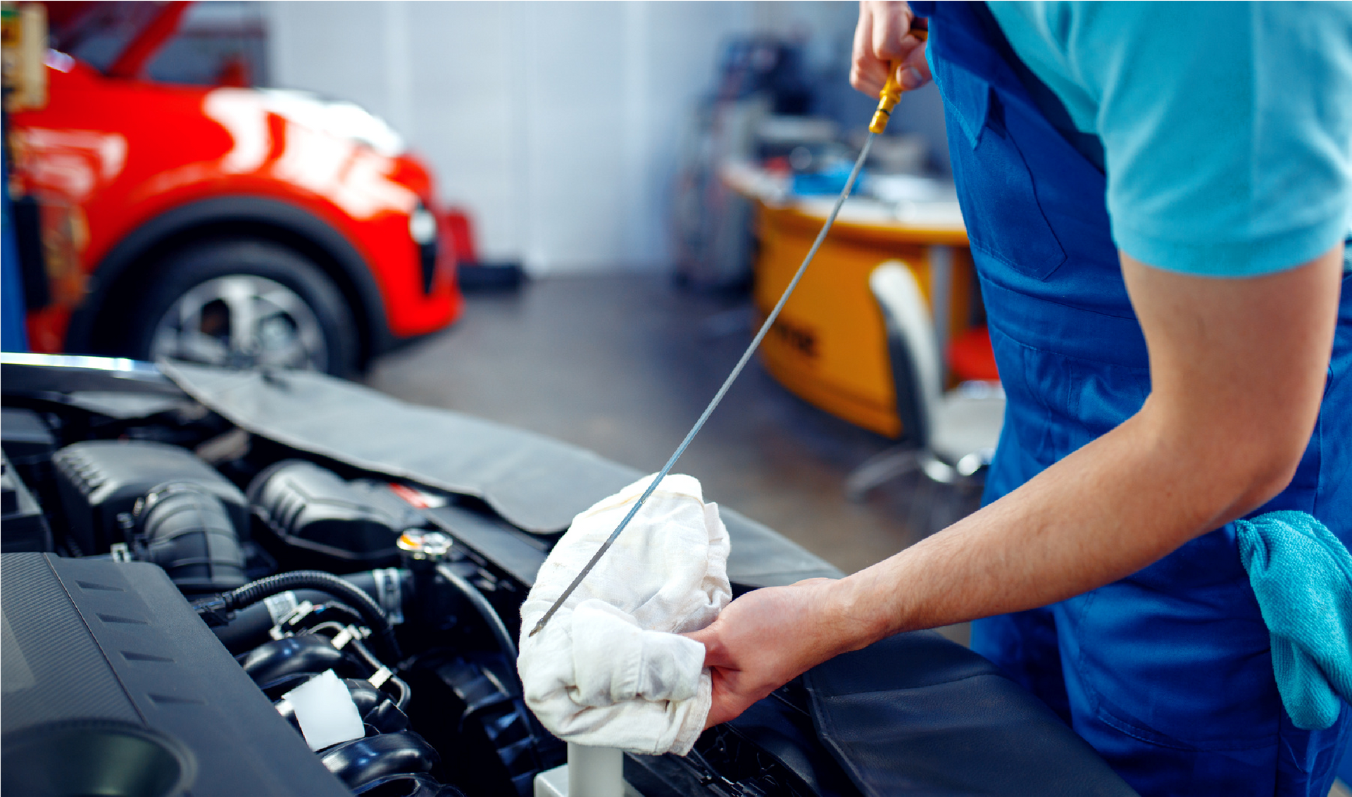 An automotive technician checks the oil level of an automobile.