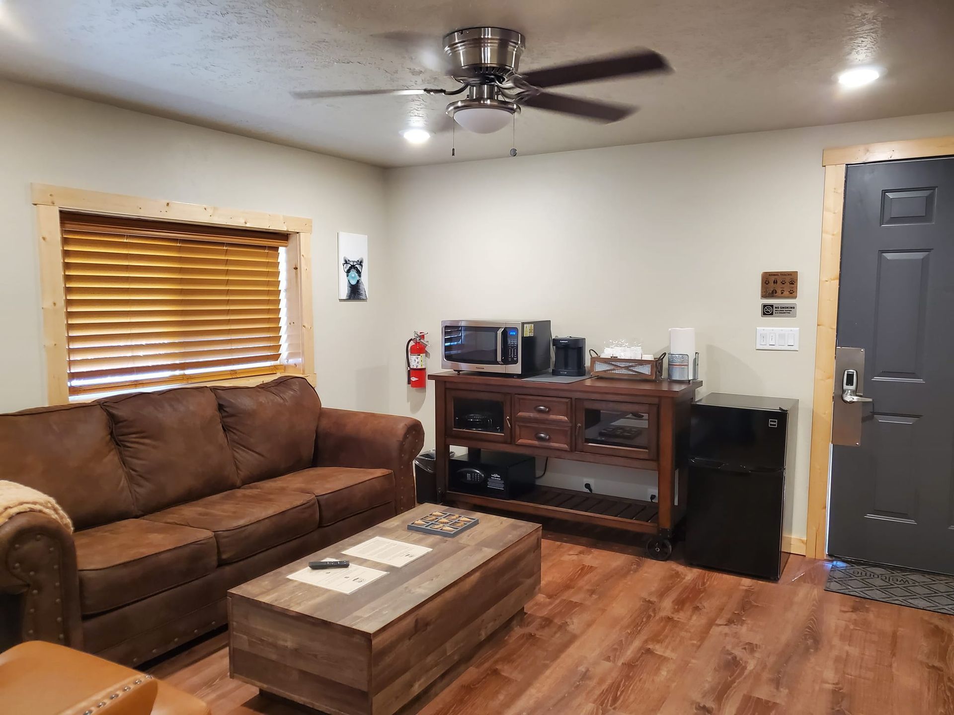 A living room with a couch , coffee table , and ceiling fan.