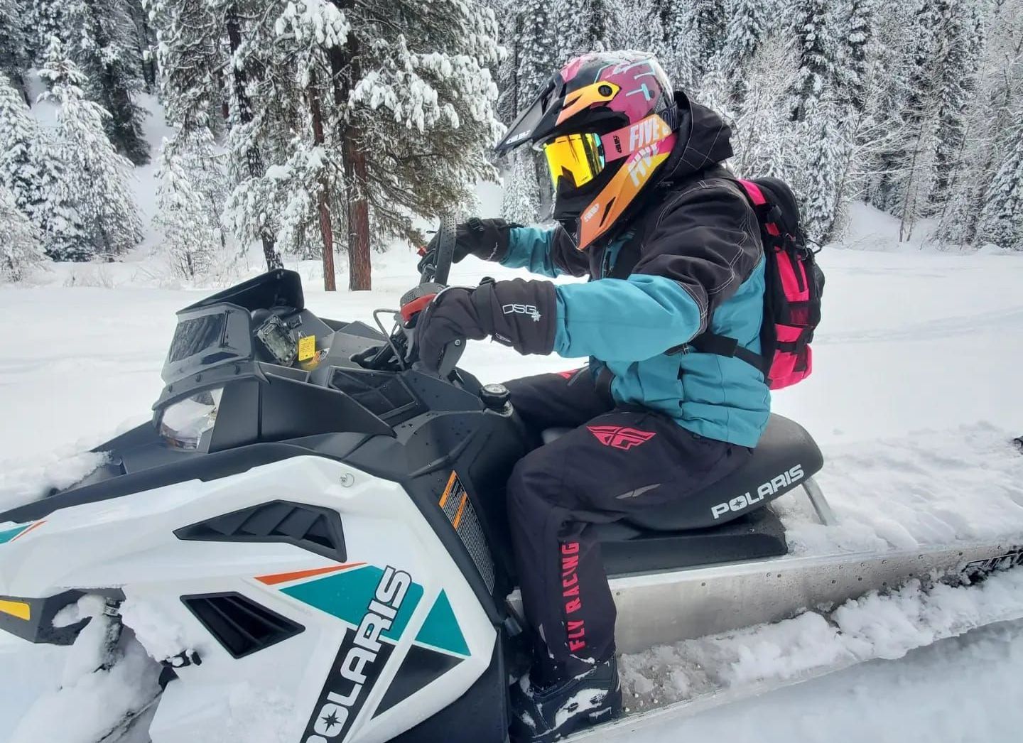 A person is riding a snowmobile in the snow.