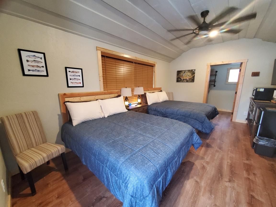 A bedroom with two beds and a ceiling fan.