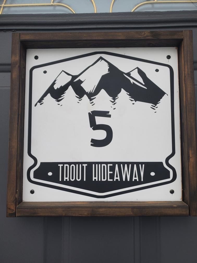 A sign that says trout hideaway on it