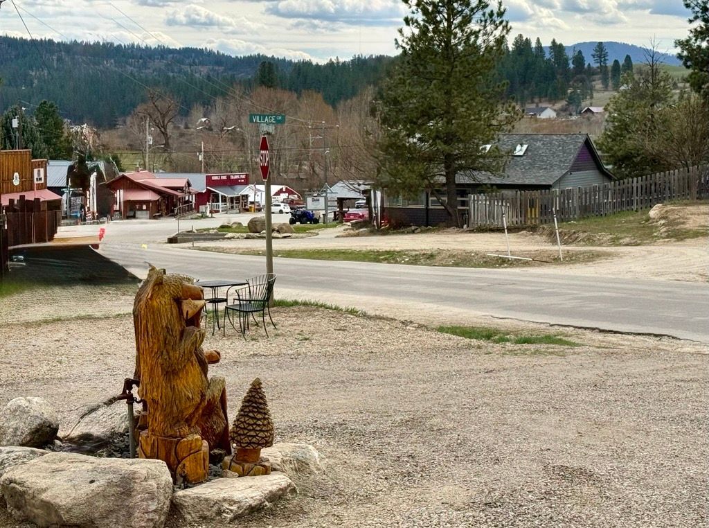 A small wooden house with a black door is sitting in the snow.