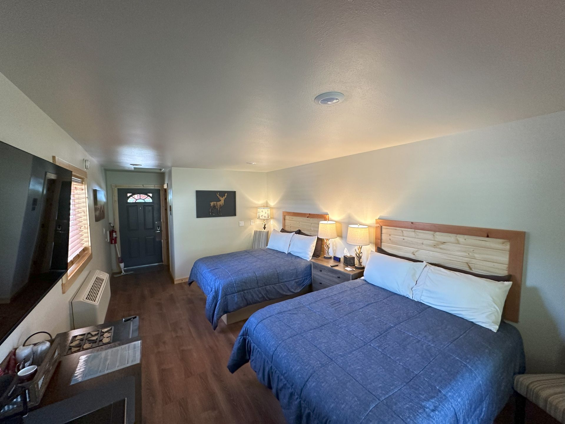 A hotel room with two beds and a dresser.