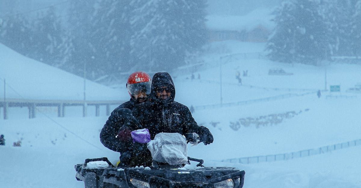 Two people are riding a snowmobile in the snow.