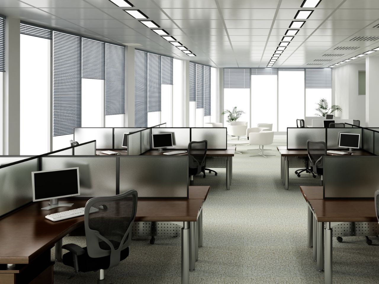 Um escritório com cubículos e um computador em uma mesa