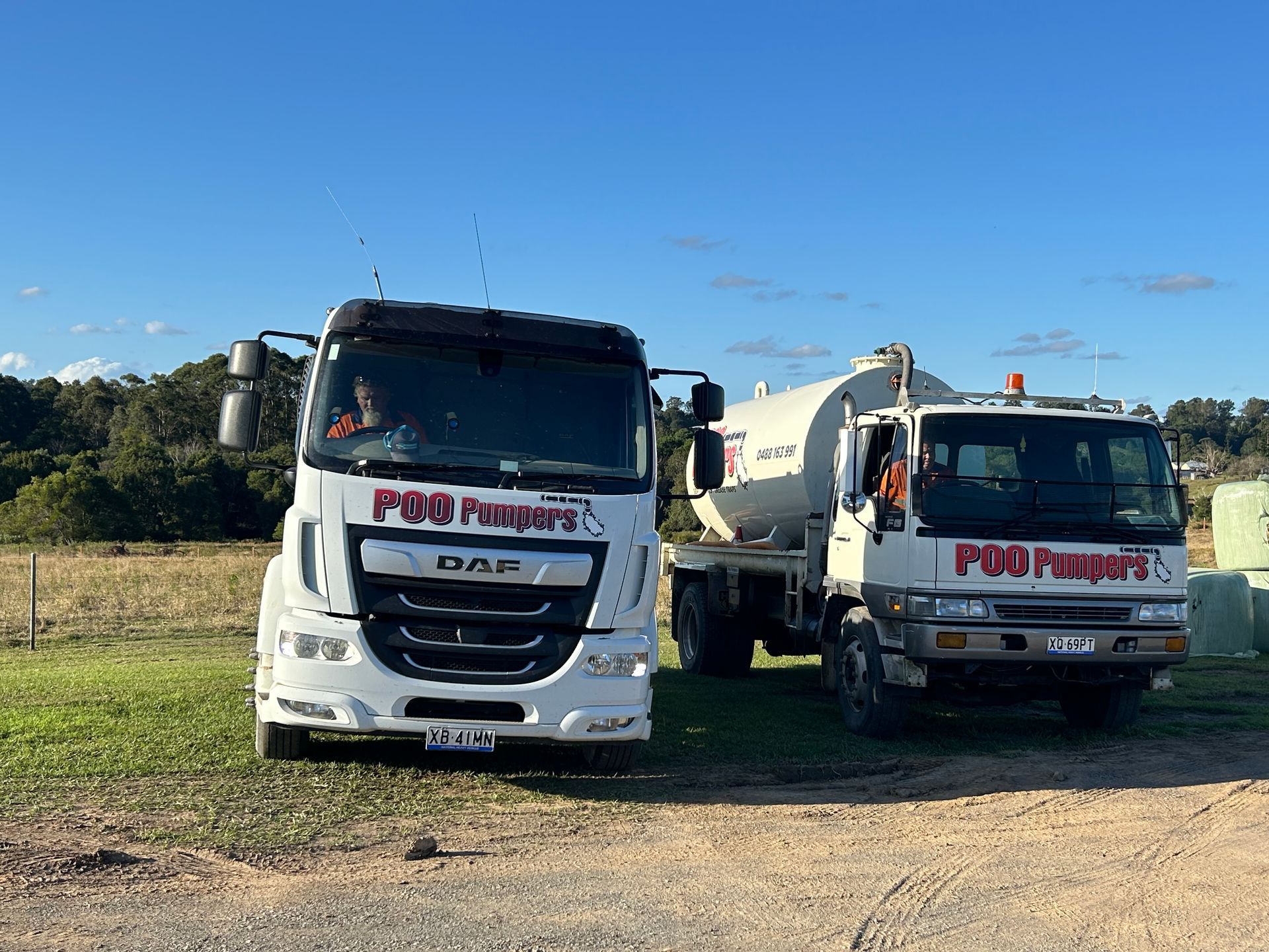 Two Septic Tank Trucks Next To Each Other — Gympie Poo Pumpers in Goomeri, QLD