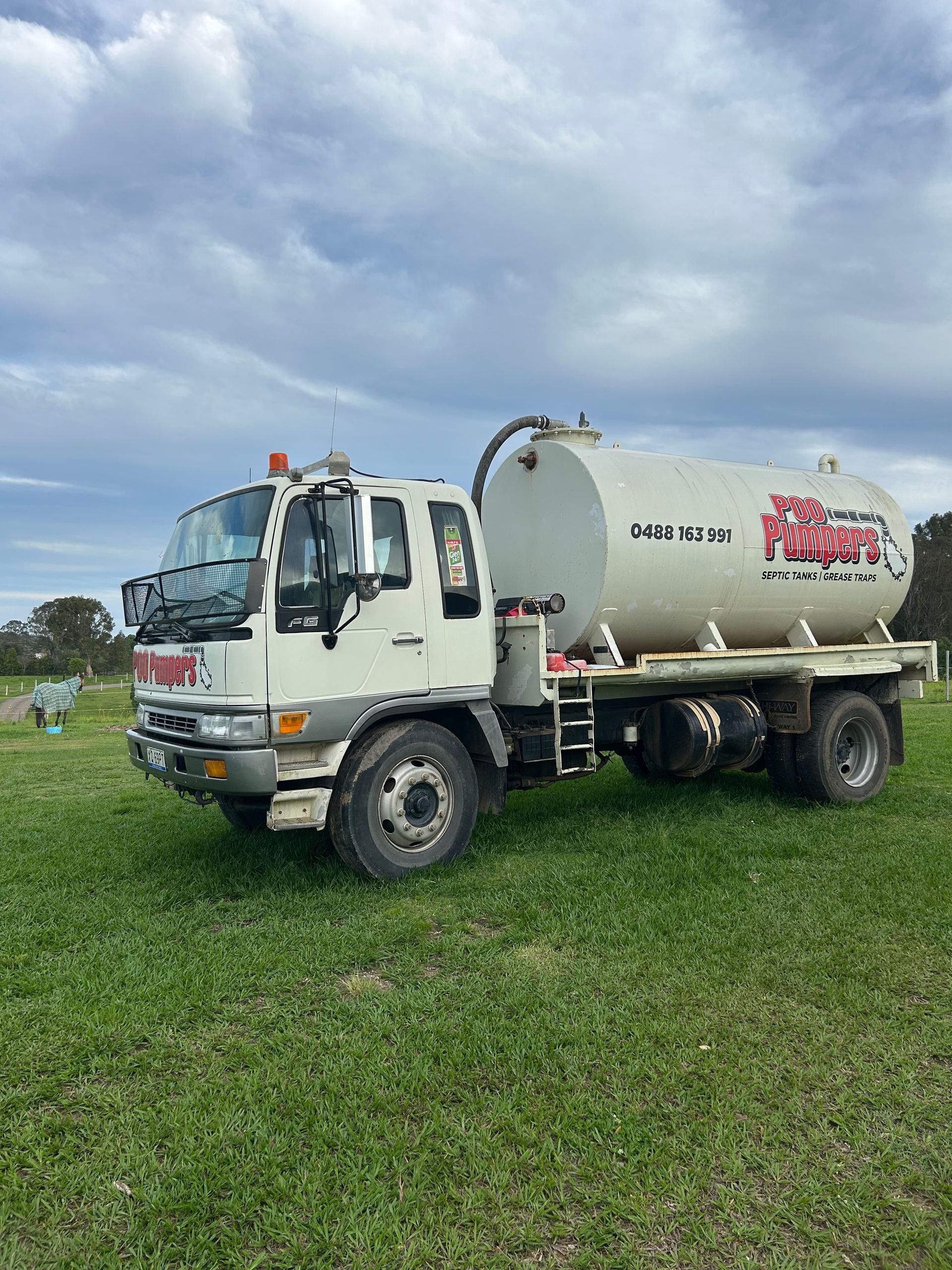 A Poo Pumpers Septic Tank Is Parked In The Dirt — Gympie Poo Pumpers in Monkland, QLD