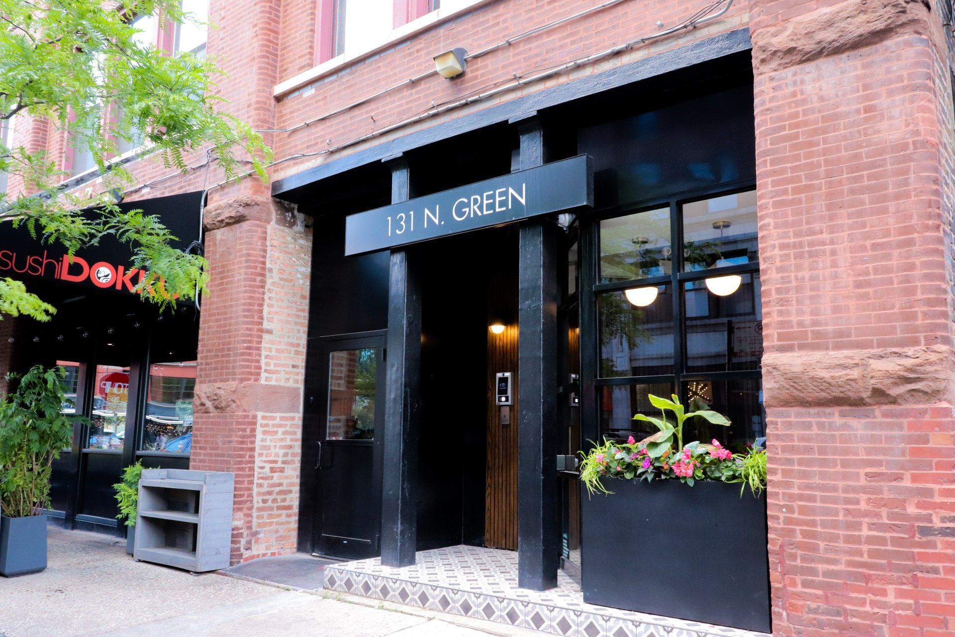 the front of a restaurant with a black door and a sign