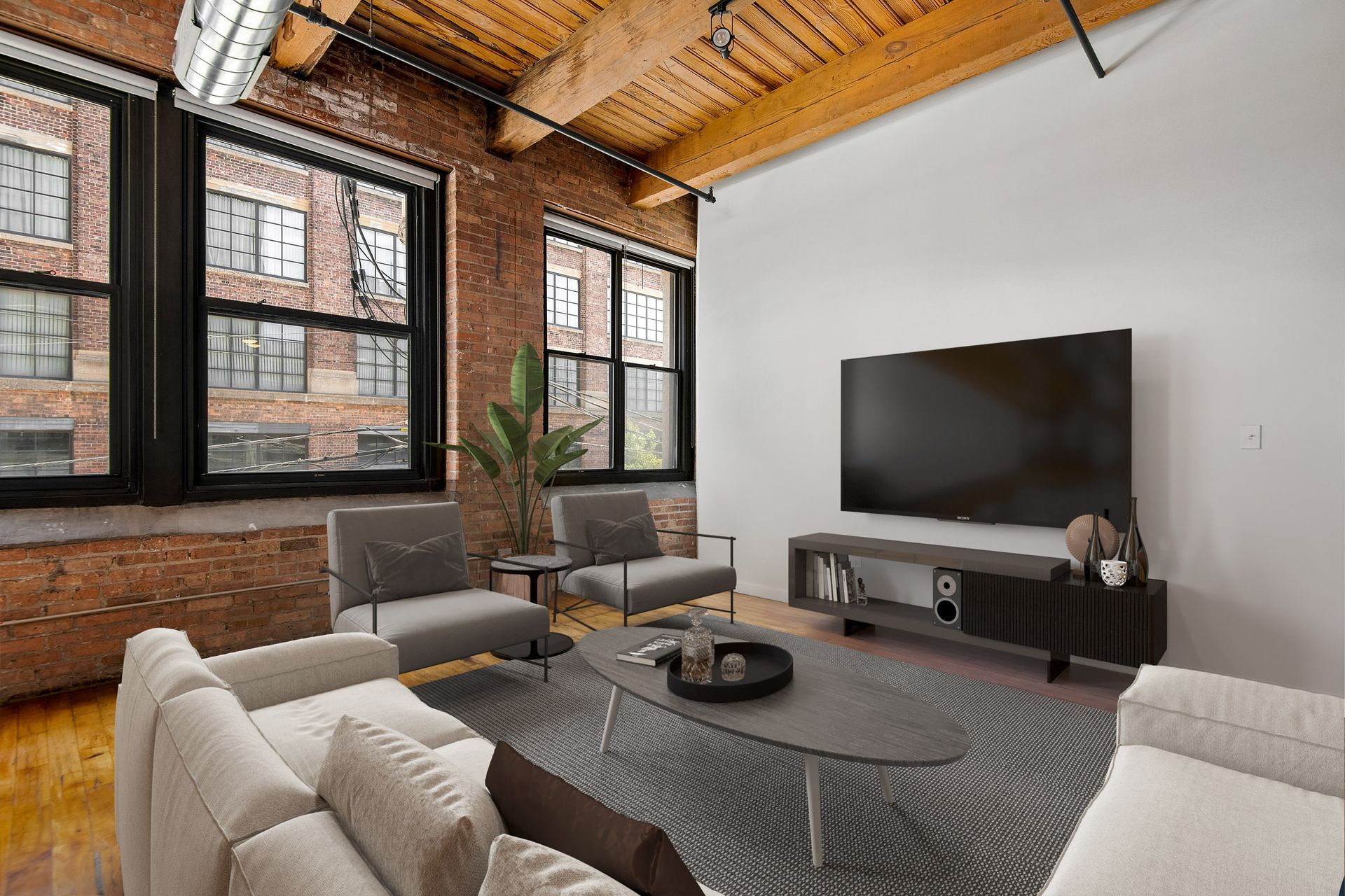 A living room with a couch , chairs , and a flat screen tv at The Lofts at Gin Alley.