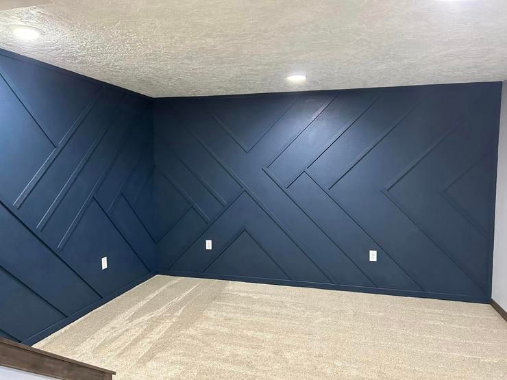 A room with a blue wall and a carpeted floor.