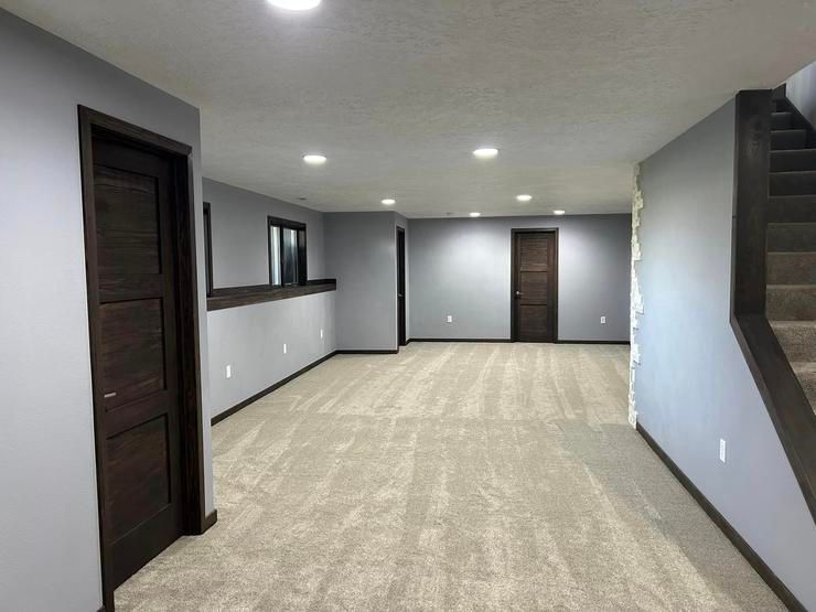 An empty basement with a staircase leading up to the second floor.