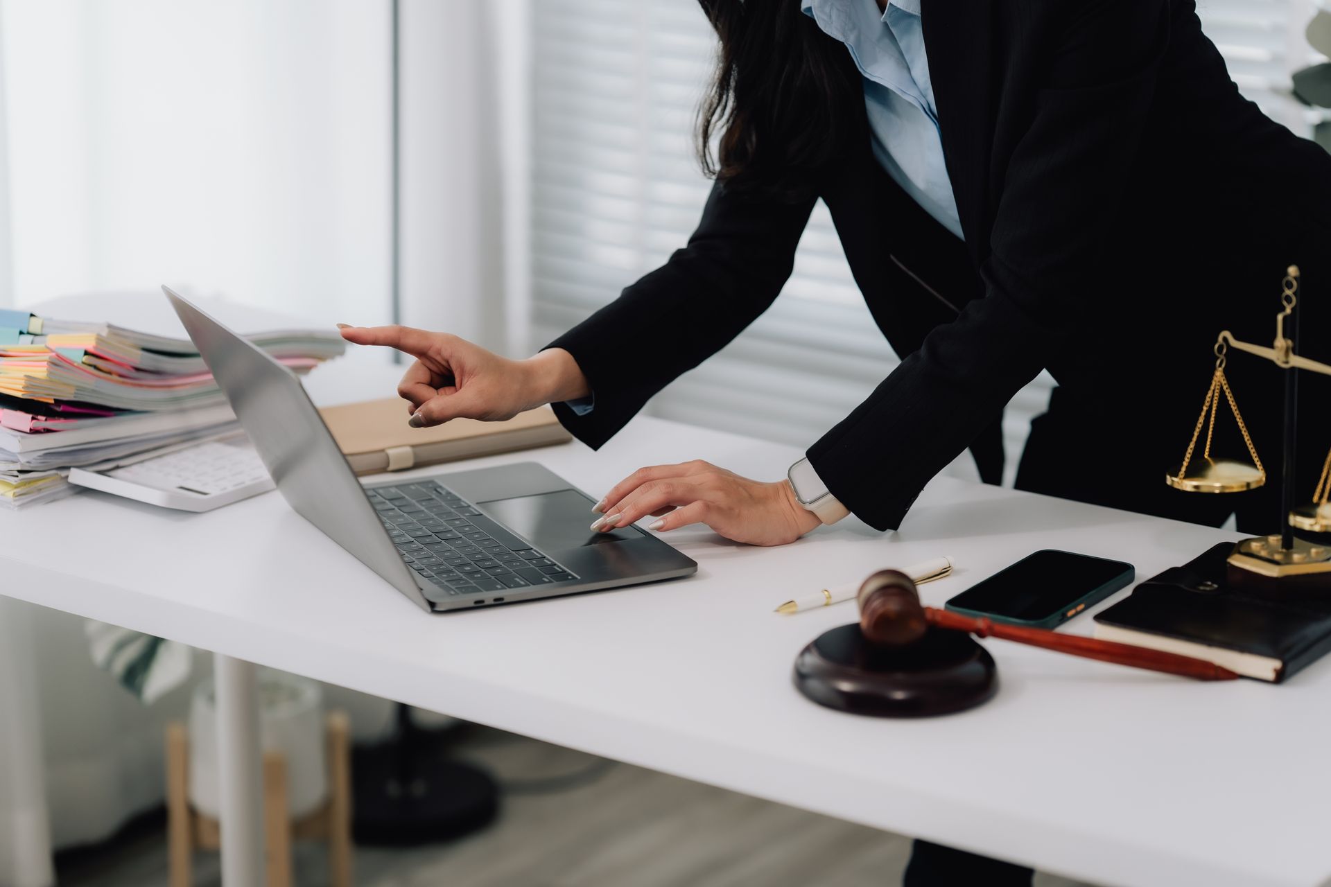 A woman is checking something on her laptop.