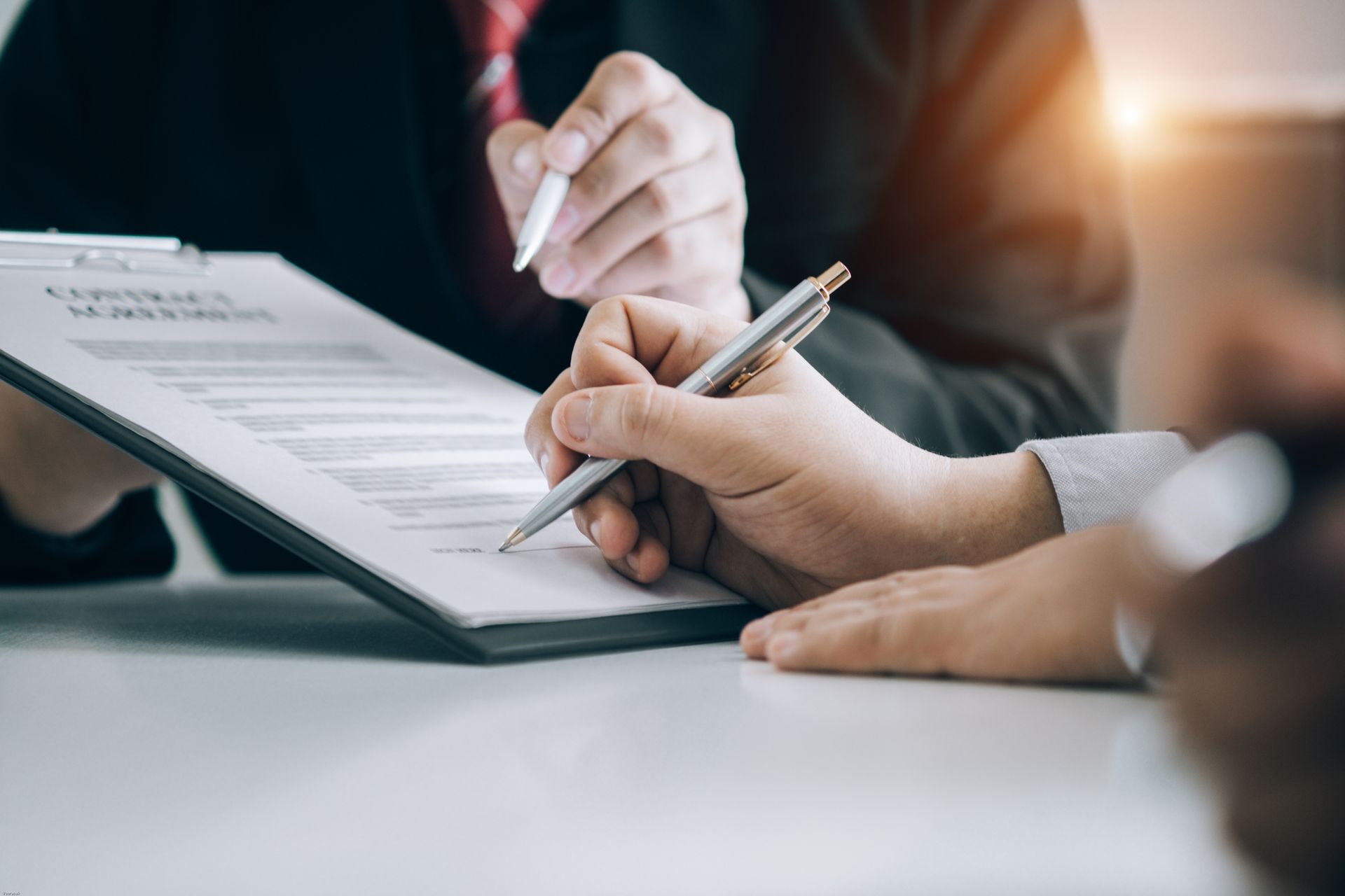 Clients signing sales contracts, representing real estate attorney guidance during the process.