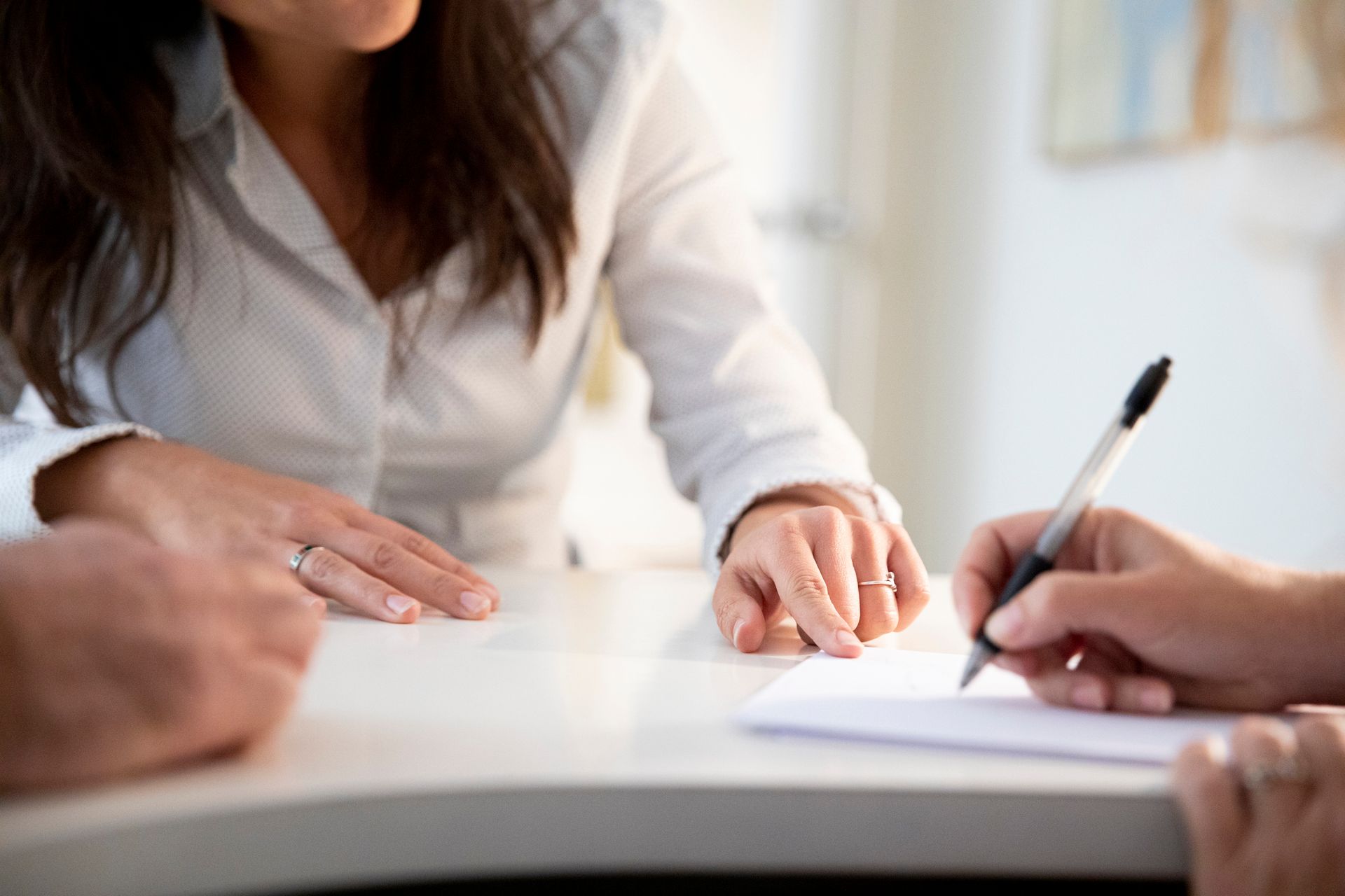 A woman is explaining a document to a client. A woman is explaining a document to a client.