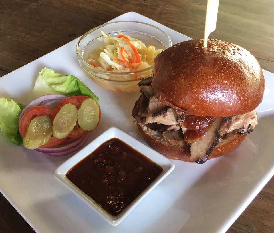 A sandwich with a toothpick in it is on a white plate