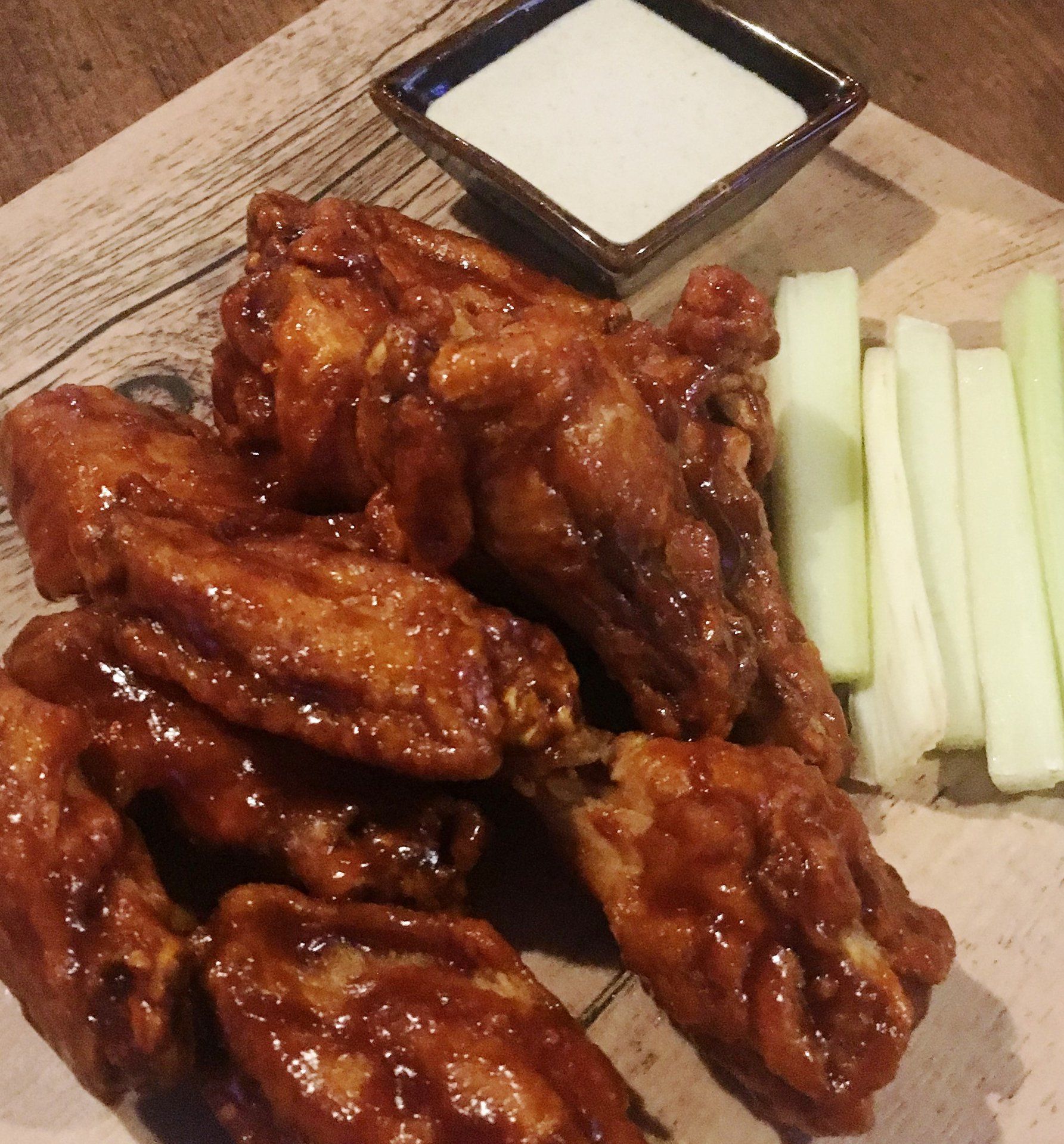 A plate of chicken wings and celery next to a bowl of ranch dressing