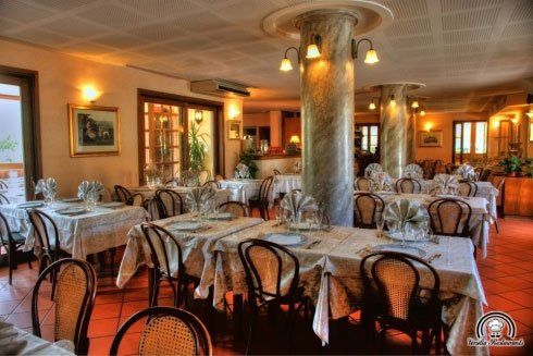 Dei tavoli apparecchiati all'interno di un ristorante