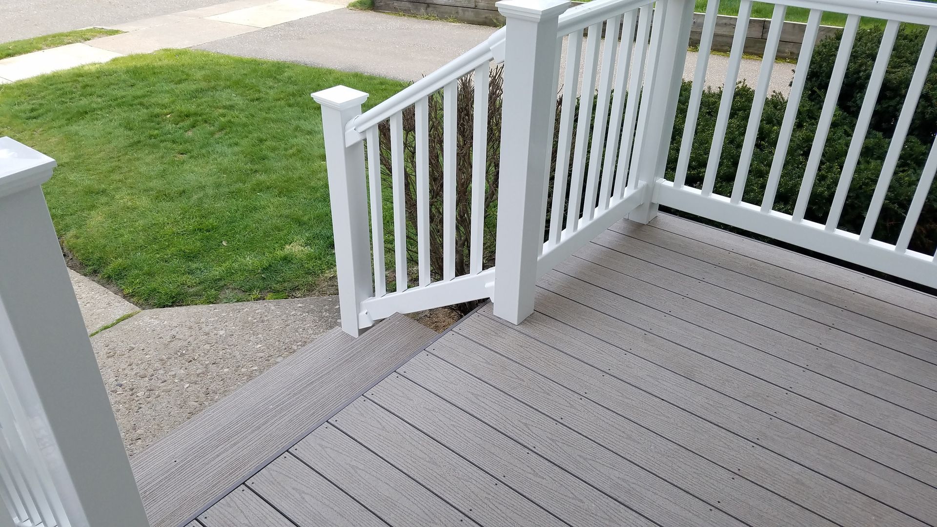 A deck with a white railing and stairs leading up to it